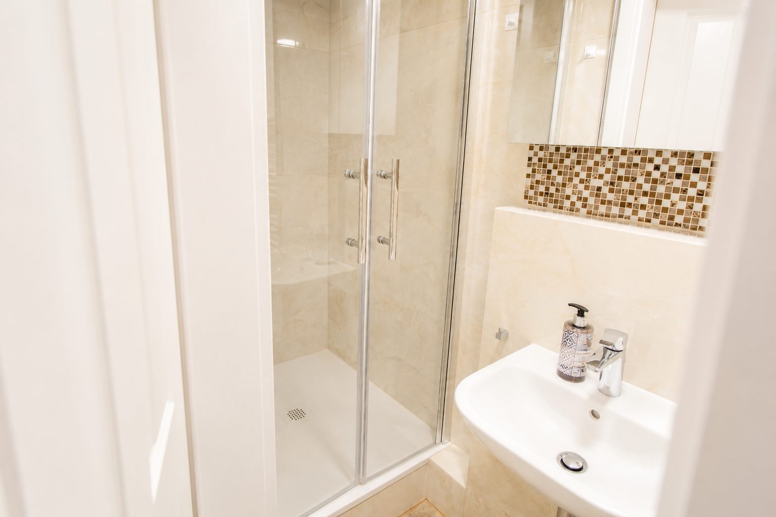 Bad im Erdgeschoss mit bodennaher Dusche, Glastür und Waschbecken